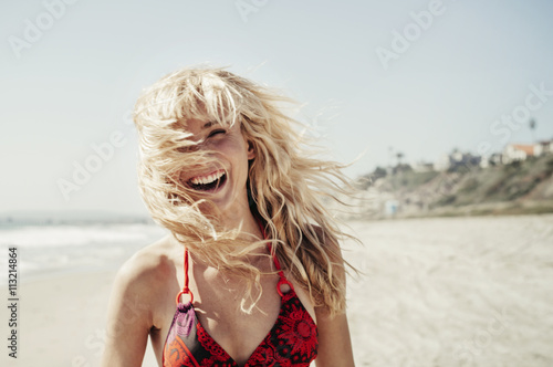 Smiling blond young woman enjoying beach