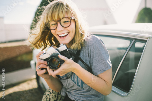 Outdoor portrait of young woman holding camera photo