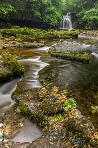 Beautiful waterfall with stream and rocks in foreground in North Yorkshire, UK. photo