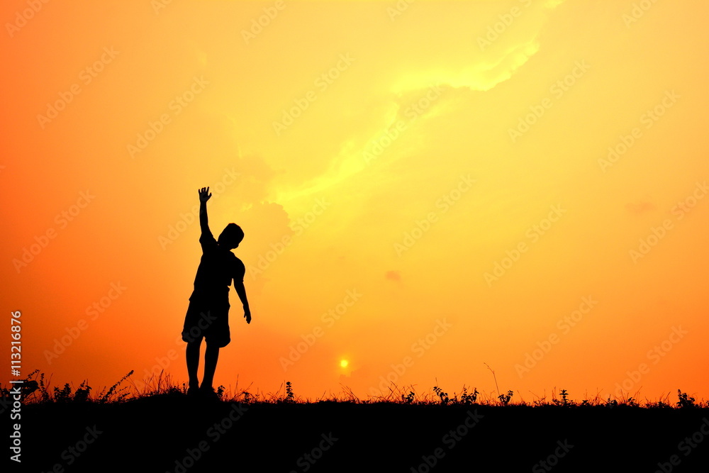 Silhouette boy hand up in the sunset. Concept big dream Silhouette boy hand up in the sunset. Concept big dream