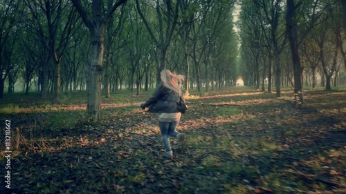 scared afraid female woman runs away escape from murderer chasing her through a dark  forest full of trees looking for help horror scene