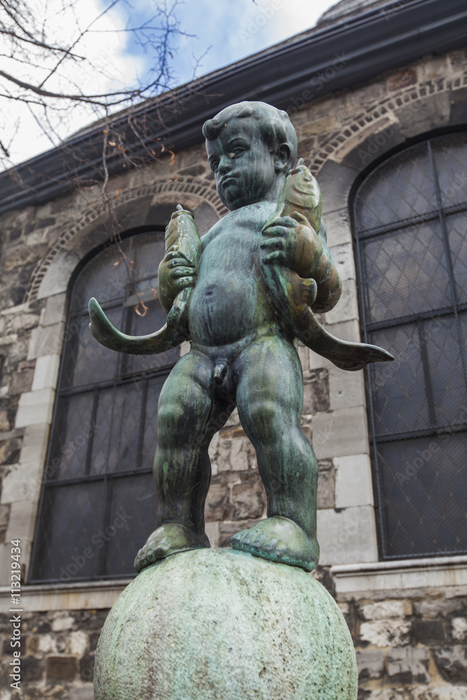 Statue of a boy holding two fishes near Aachen Cathedral