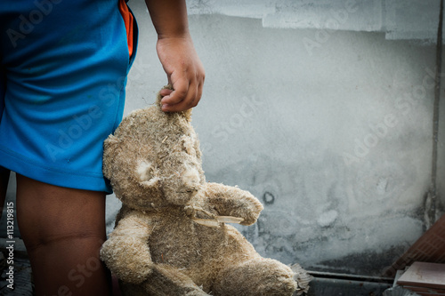 Poor child holding a teddy bear