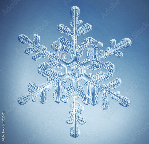 Close-up of snowflake against blue background photo