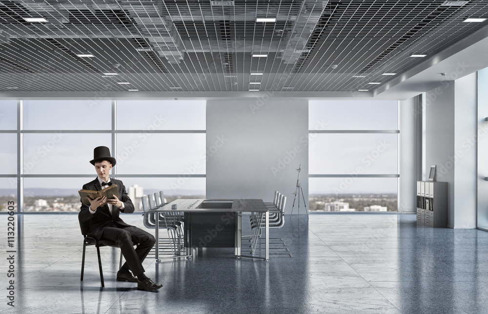 Businessman in cylinder reading book Businessman in cylinder reading book