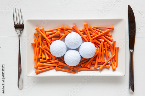 White ceramic dishes with golf balls and wooden tees