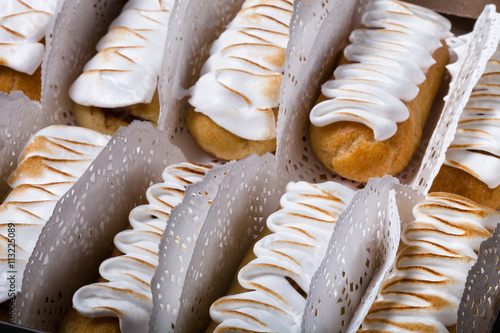 Fresh homemade eclairs white cream and chocolate filling on a da photo