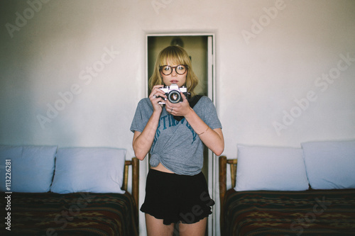 Portrait of young woman taking photo with camera photo