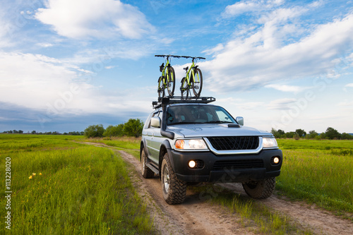 4x4 SUV with two bicycles on roof rack photo