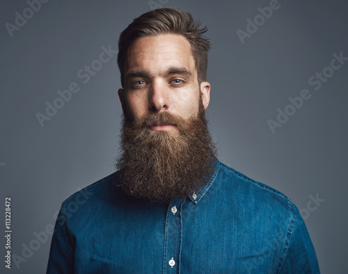 Bearded man in blue denim with tired expression
