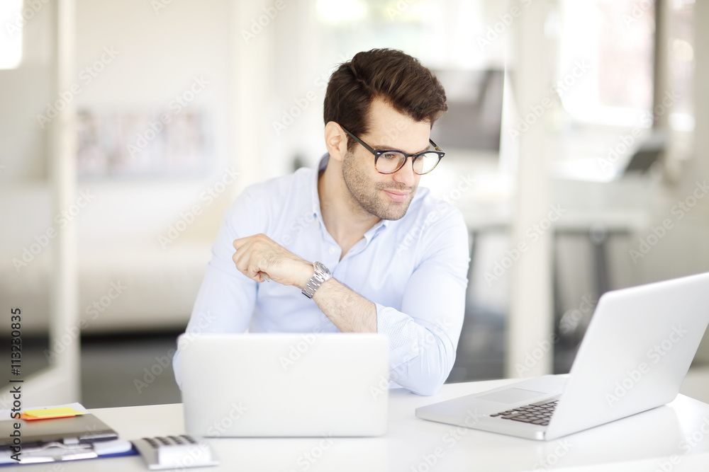 Young professional business man working on laptop at office