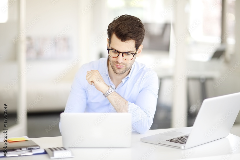 Young professional business man working on laptop at office Young professional business man working on laptop at office