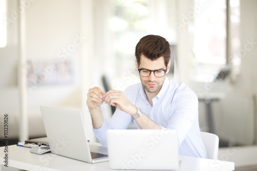 Young professional business man working on laptop at office