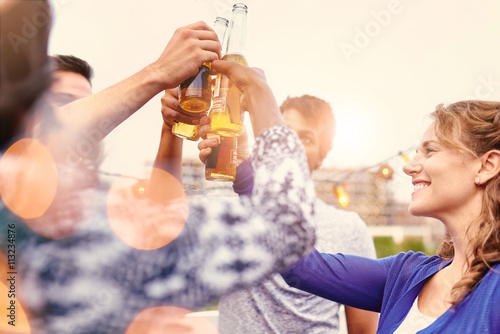 Sticker Multi-ethnic millenial group of friends partying and enjoying a beer on rooftop