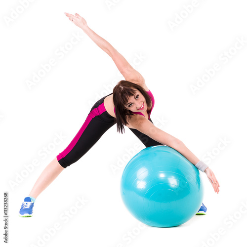 Young smiling woman makes exercise with fitball