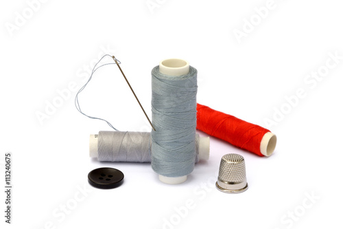 Needle, thimble, scissors, thread and knob isolated on white background
