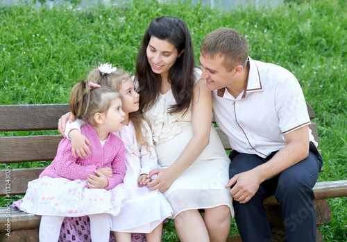 family on outdoor, pregnant woman with child and man, city park, summer season, green grass and trees © soleg