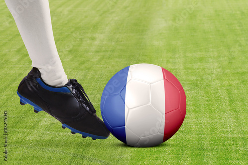 Foot of soccer player kicking ball at field