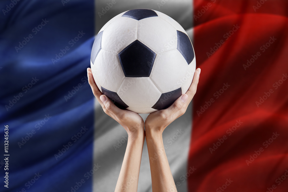 Naklejka premium Hands hold ball with flag background of France