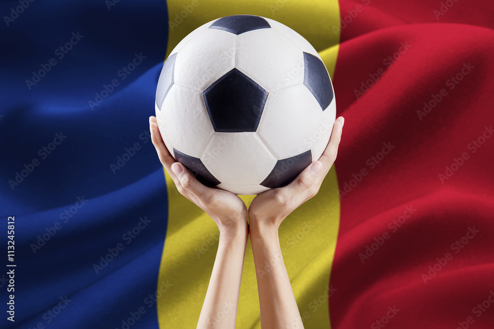 Fototapeta premium Hands holding ball with flag of Romania