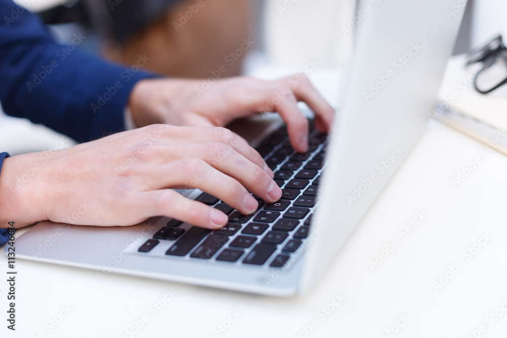 Cheerful young businessman is using notebook Cheerful young businessman is using notebook
