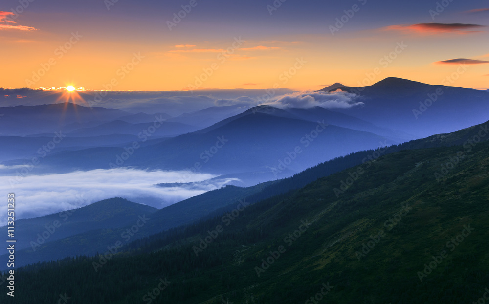 Sunrise landscape of foggy and cloudy mountain valley. 