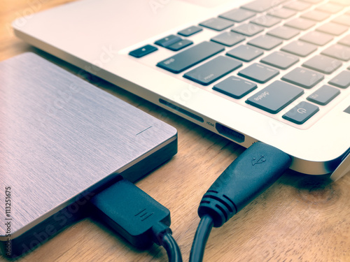 Obraz na płótnie External or portable hard drive (HDD) connected to laptop computer for transfer