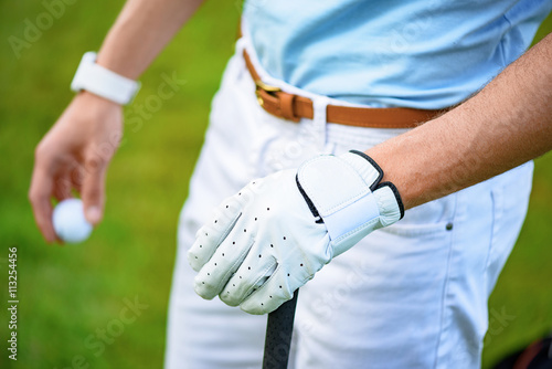 Golfer holding ball and golf club