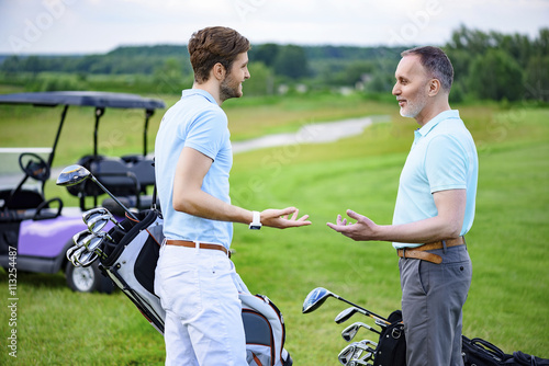 Two friends talking on their way to tee-off