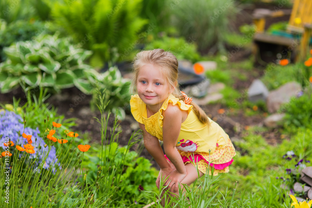 girl in the garden among flowers in a summer sunny day girl in the garden among flowers in a summer sunny day