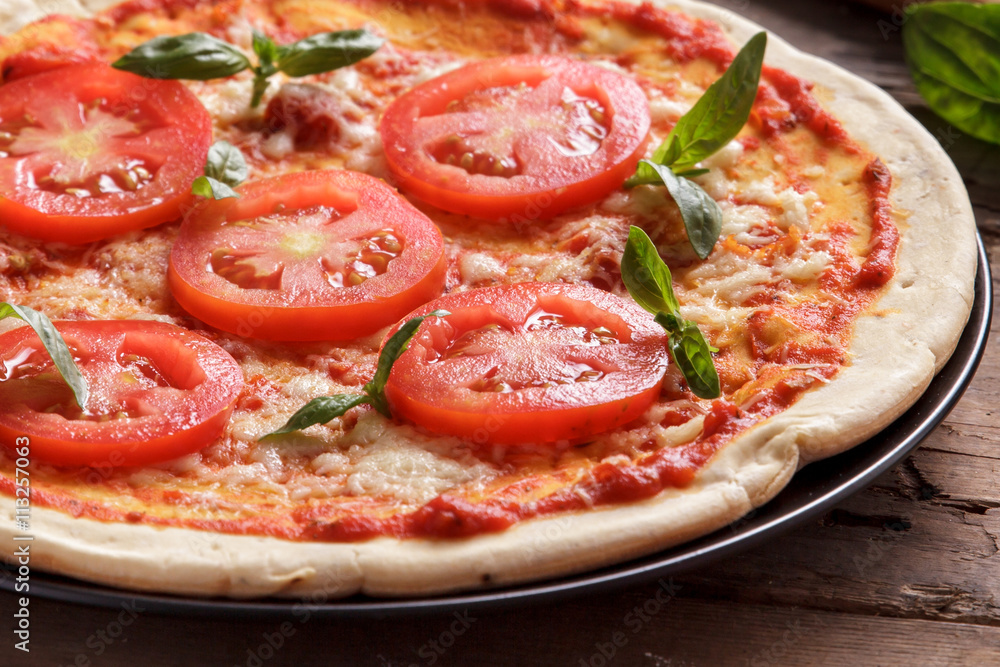 italian homemade pizza with sliced tomato topping