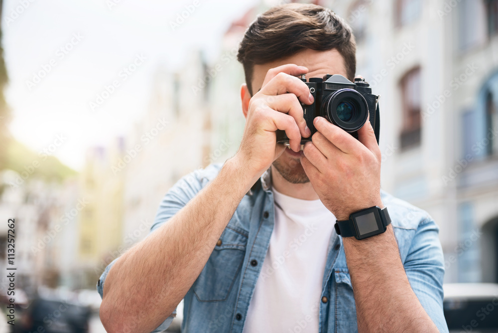 Pleasant cheerful man holding photo camera