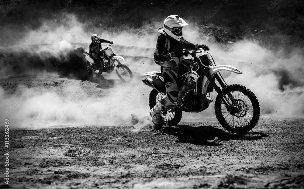 Motocross racer accelerating in dust track, Black and white photo