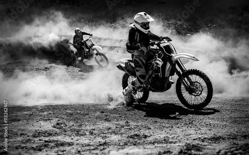 Motocross racer accelerating in dust track, Black and white photo