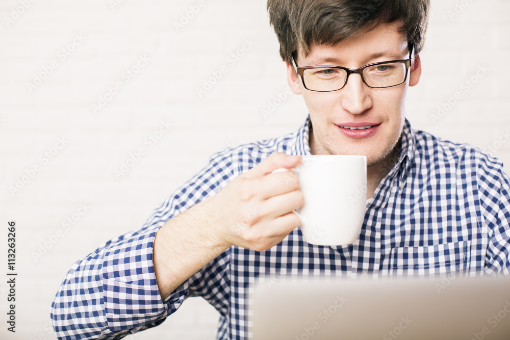 Man drinking coffee and using laptop Man drinking coffee and using laptop