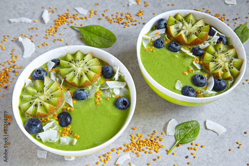 breakfast green smoothie bowl topped with fruits and berries