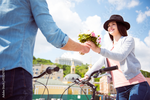 Man offering flowers to woman in hat