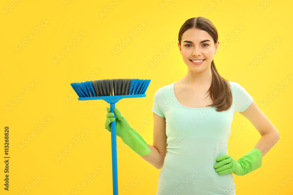 Female cleaner on yellow background Female cleaner on yellow background