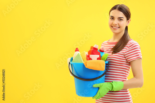 Female cleaner on yellow ba...