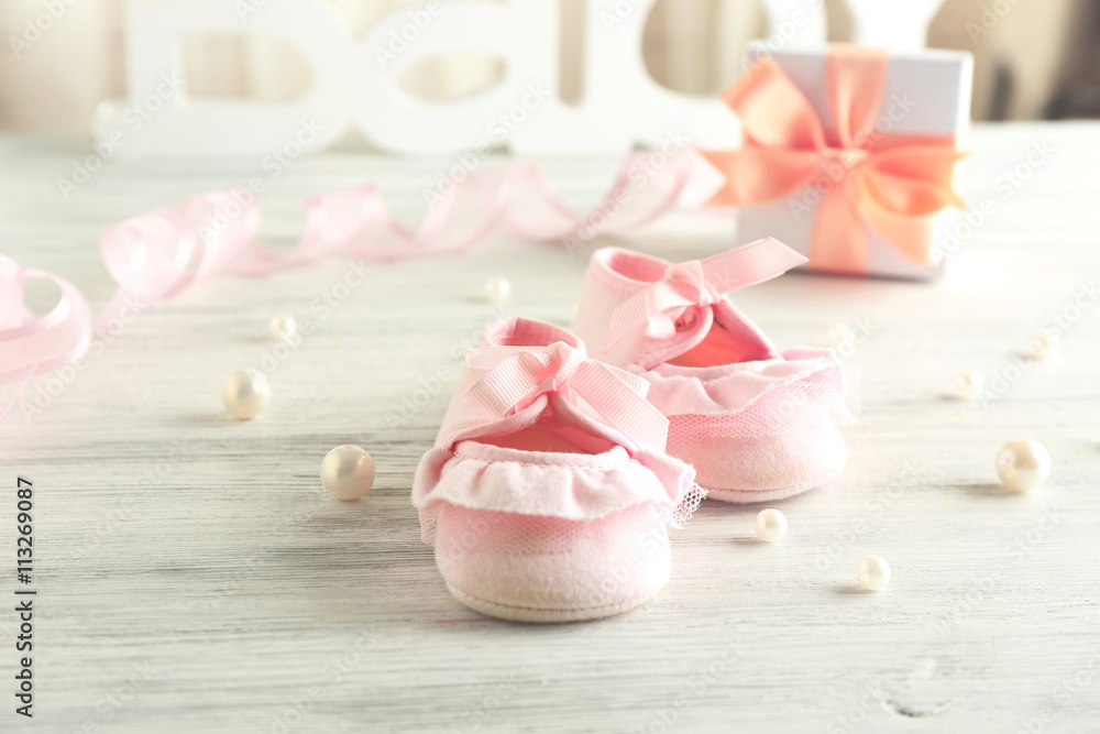 Baby booties on wooden table, closeup Baby booties on wooden table, closeup