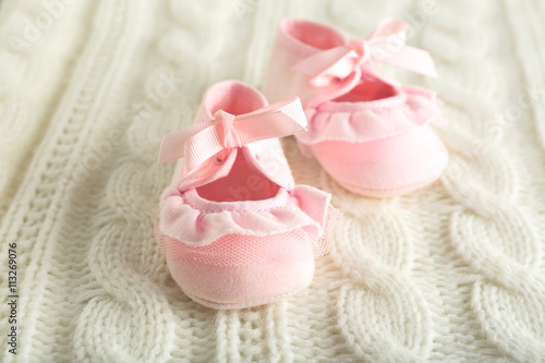 Baby booties on knitted plaid, closeup