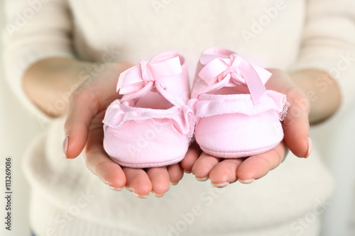 Woman holding baby booties, closeup