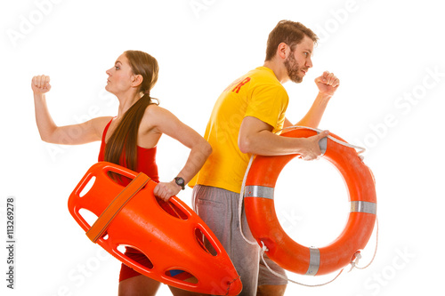 Lifeguards running with rescue ring buoy on duty.