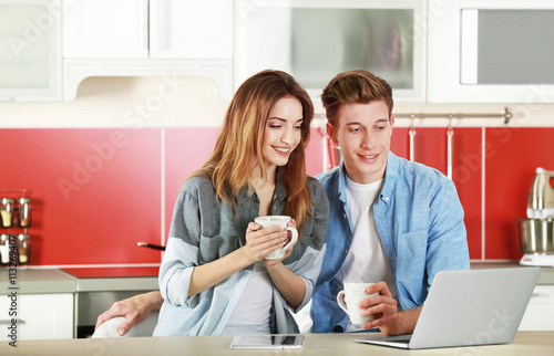 Couple with laptop in kitchen