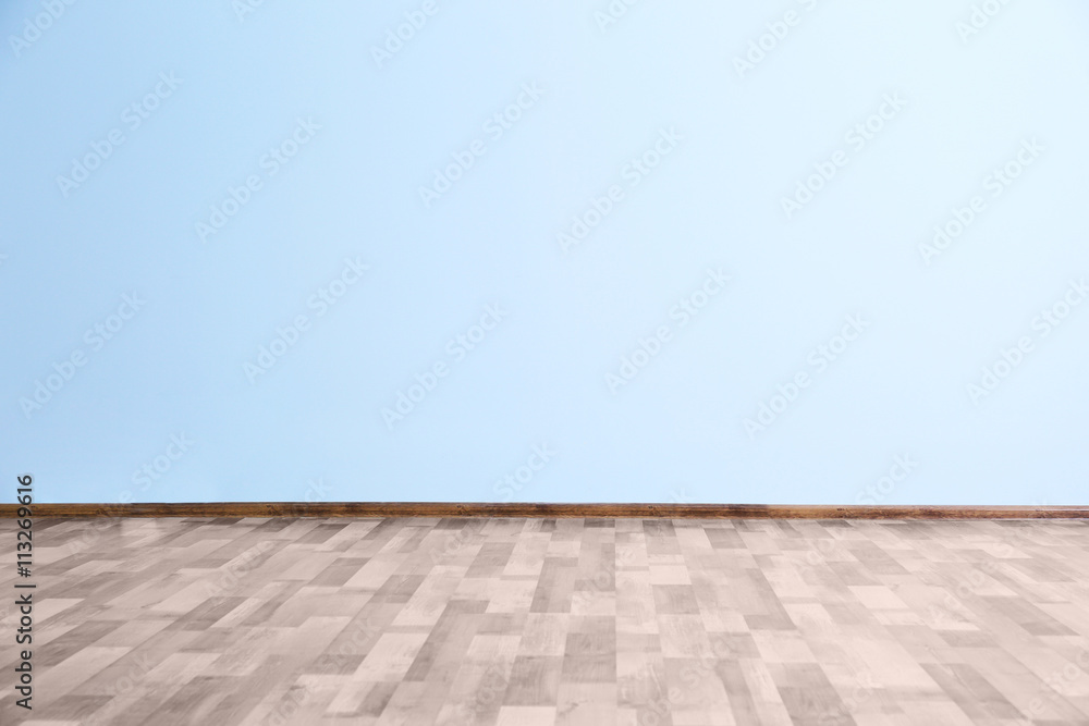 Empty room with blue wall and wooden floor
