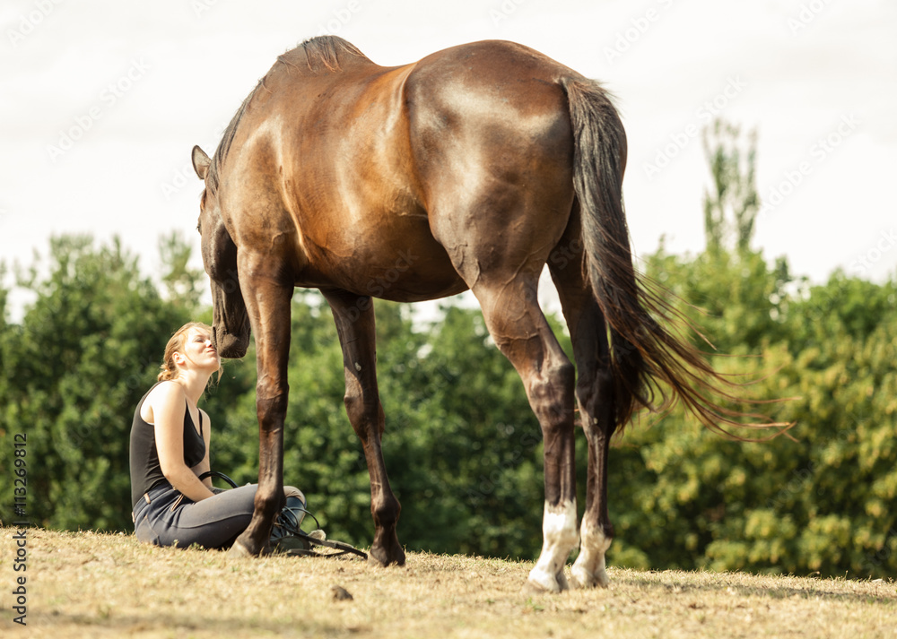 Obraz premium Young woman girl taking care of horse.