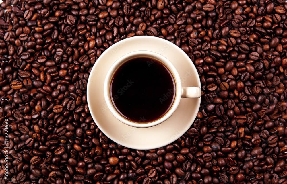 Coffee beans in coffee cup isolated on white Coffee beans in coffee cup isolated on white