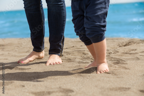 Mother and child walking on a sandy beach