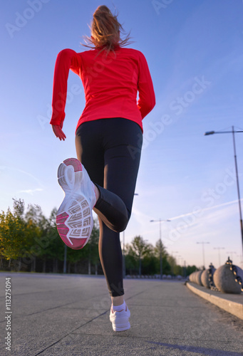 Morning jogging. Woman runinng in the park. Selective focus at the shoe