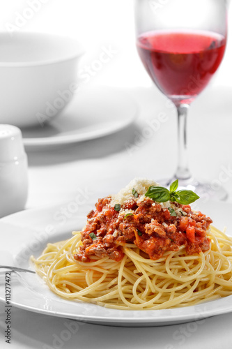 italian spaghetti bolognese topped with cheese and basil
